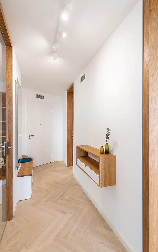 Garderoben-Design von Matthias Knab im Collini-Center Mannheim: Maßgefertigte Flurlösung mit integrierter Sitznische aus Holz; minimalistische Raumplanung zur Optimierung der Walkways im Eingangsbereich.